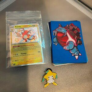 one shiny Pokémon cards with 12 sleeves and a Jirachi pin